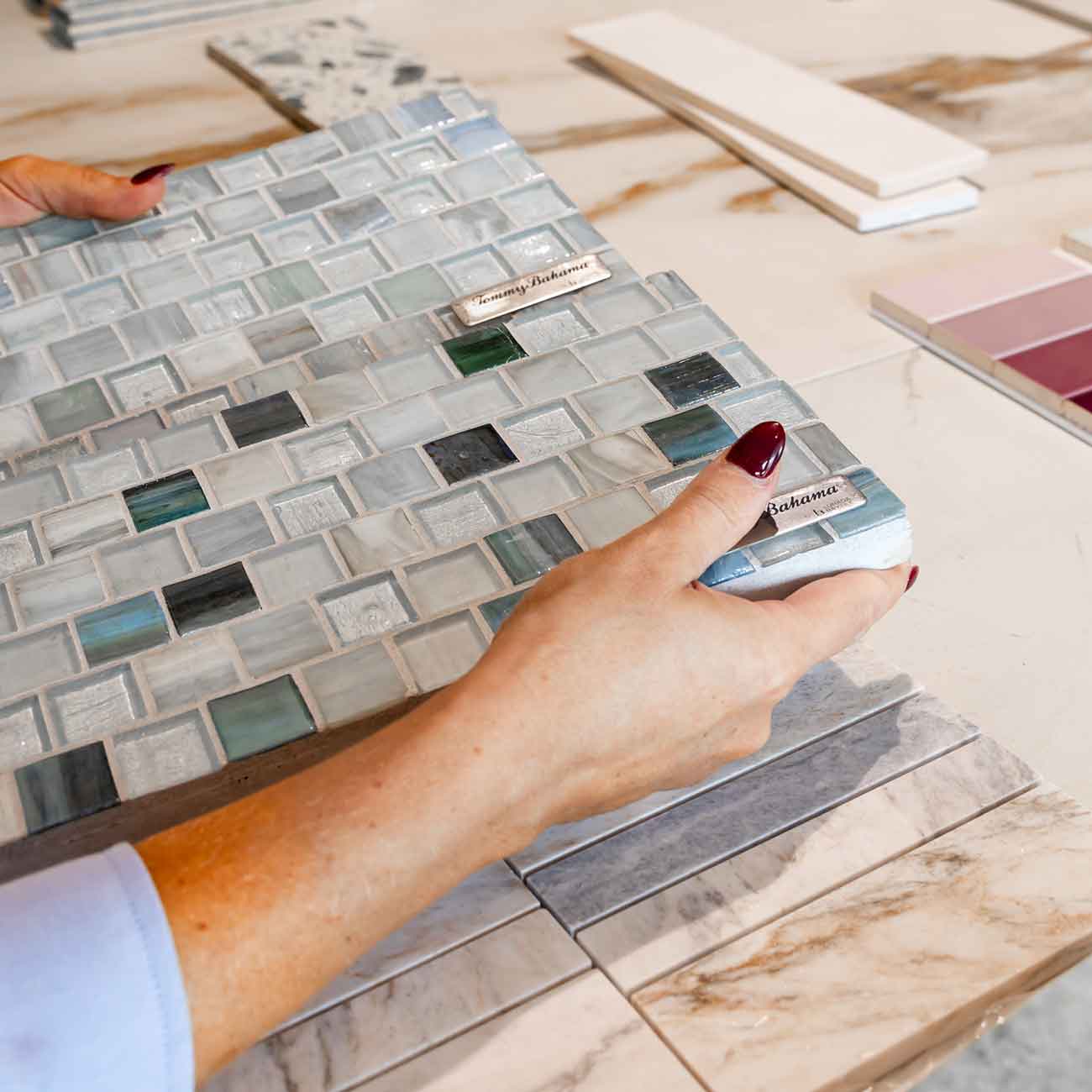 Person examining a sheet of beautiful glass tiles